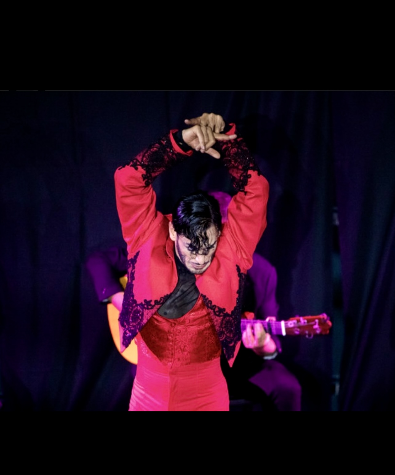 Un homme authentique en costume rouge interprète du flamenco.