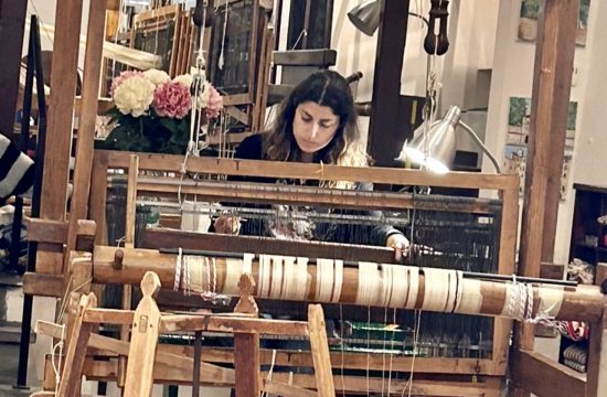 Une femme tisse sur un métier à tisser en bois à Lucca.