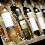 Une rangée de bouteilles de vin privées importées exposées sur une étagère en bois au Salon des vins d'importation privée.