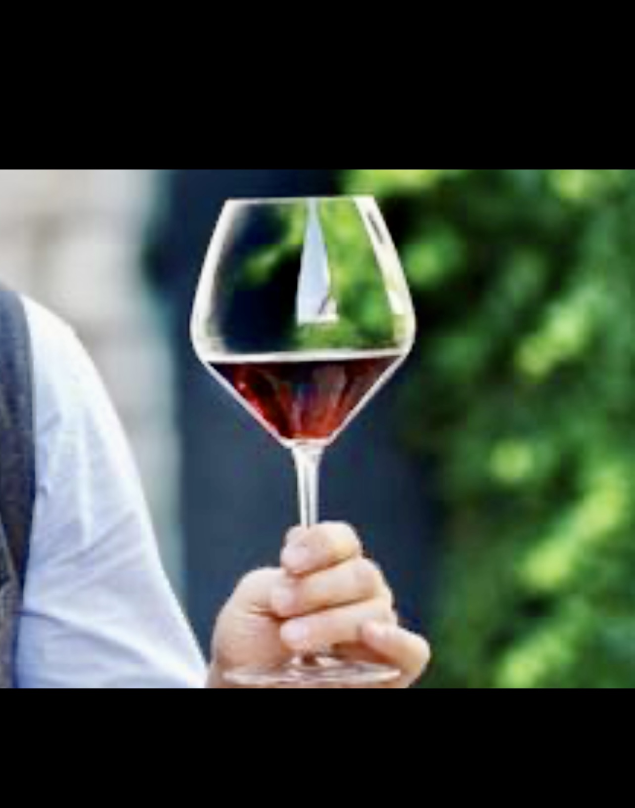 Un homme présentant un verre de vin au Salon des vins d'importation privée.