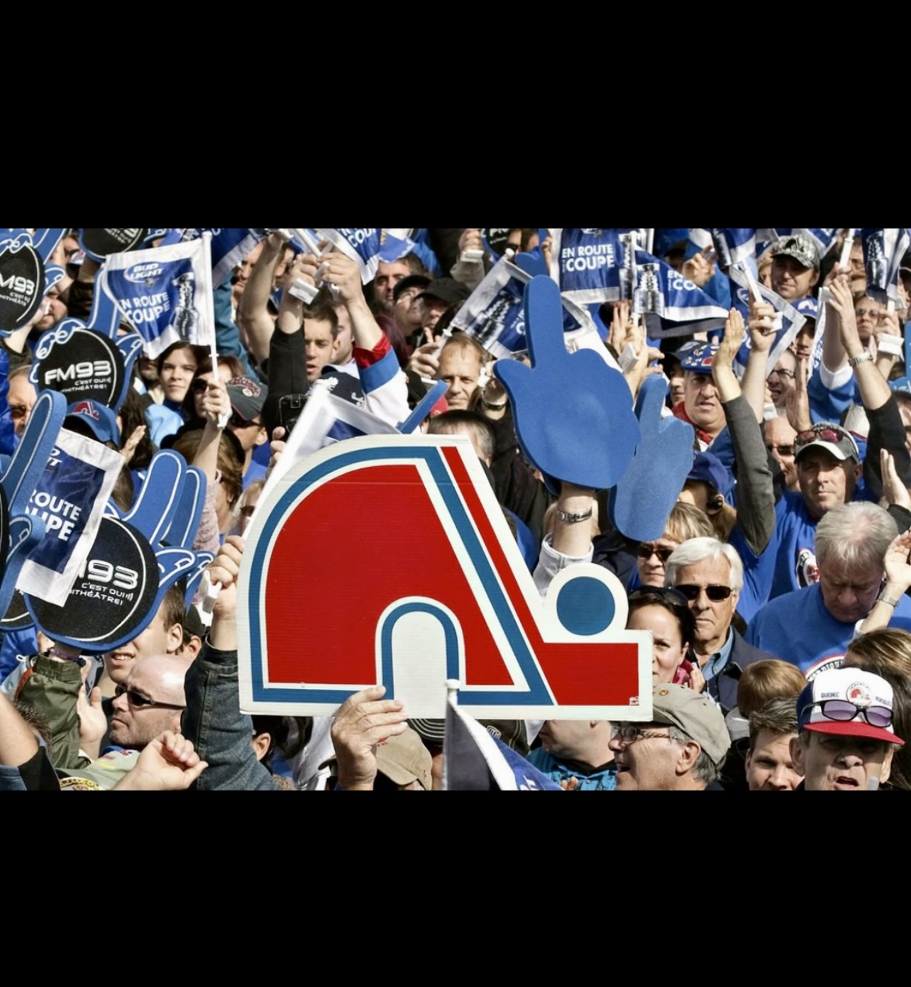 La presse sportive en folie capturant une foule de personnes brandissant une pancarte des Canadiens de Montréal.