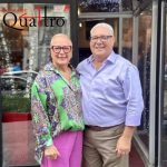 Un homme et une femme debout devant un restaurant, découvrant la délicieuse gastronomie Quattro.