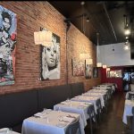 L'intérieur d'un restaurant avec une fresque murale représentant l'accueil et la gastronomie de Quattro.