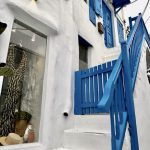 La Grèce : Inoubliable et… fort intéressant ! (2e partie) - Une maison blanche avec des volets bleus et des escaliers.
