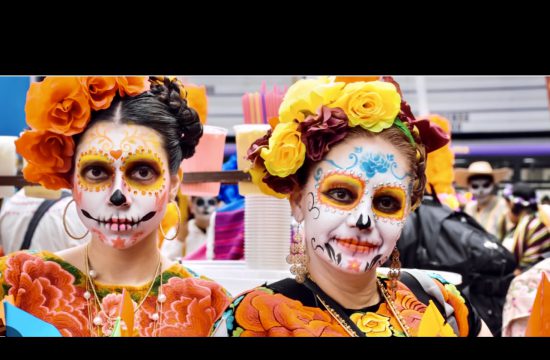 Trois femmes maquillées avec un crâne en sucre posent pour une photo lors de la Journée des Morts.