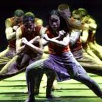 Un groupe de danseurs se produisant sur scène, mettant en valeur la chorégraphie envoûtante du Livre de la jungle d’Akram Khan.