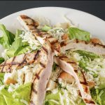 La Belle Place propose une délicieuse salade de poulet sur une assiette blanche immaculée.