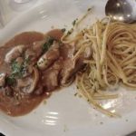 La Piccola, un charmant resto de quartier, présente une assiette de spaghettis et de viande sur une table.