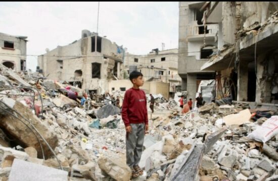 Un garçon palestinien se tient debout dans les décombres d’un bâtiment détruit.