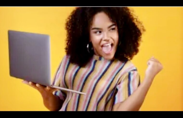 Une femme aux cheveux bouclés tenant un ordinateur portable pour se démarquer dans les candidatures en mettant en valeur ses compétences et son expérience dans son CV.