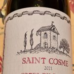 Une bouteille de vin Saint Cosme, l'un des deux excellents Côtes-du-Rhône, est élégamment posée sur une table.