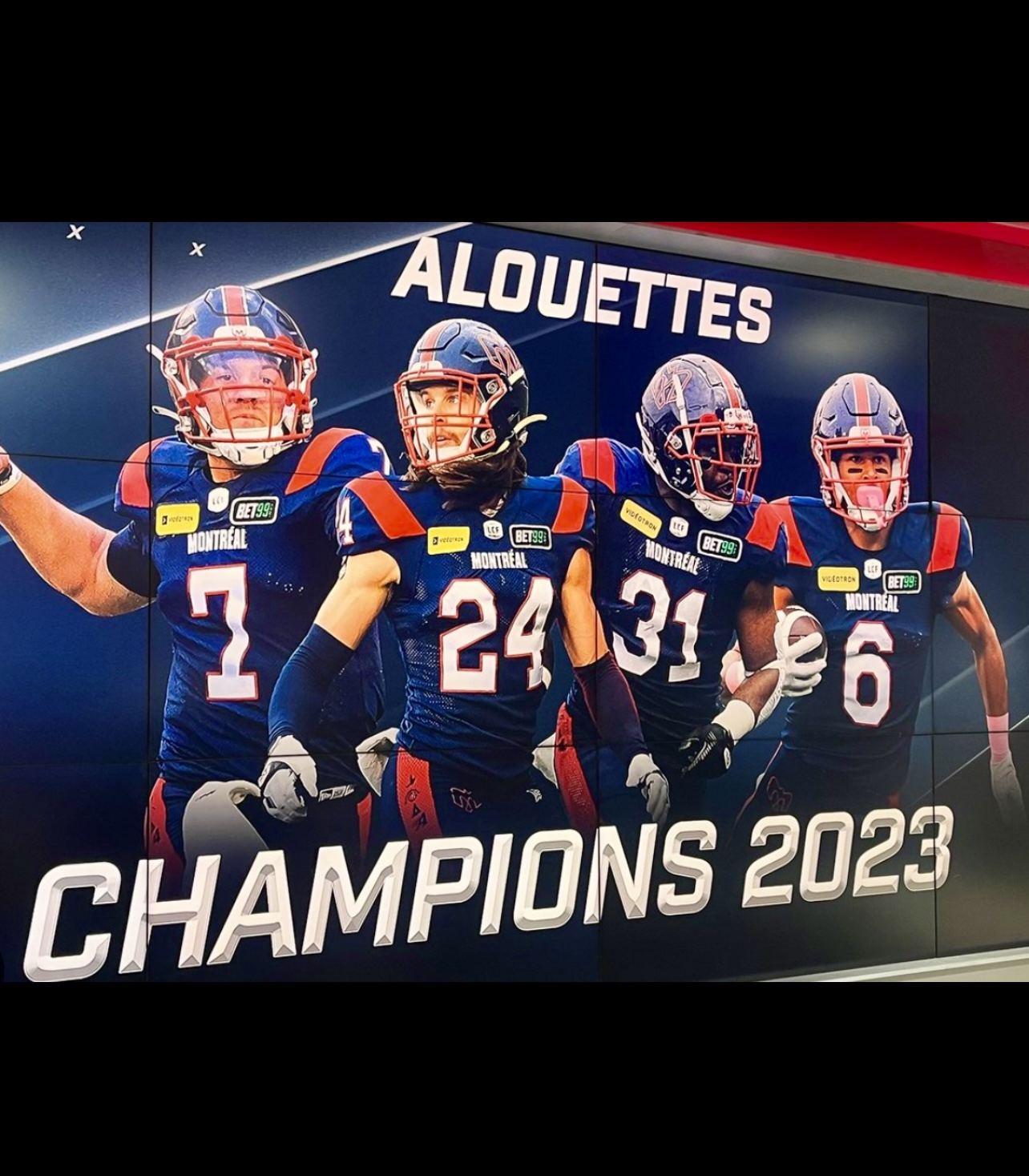 Une bannière célébrant la victoire des Alouettes comme champions en 2023 avec les mots « Alouettes Champions 2023 ».