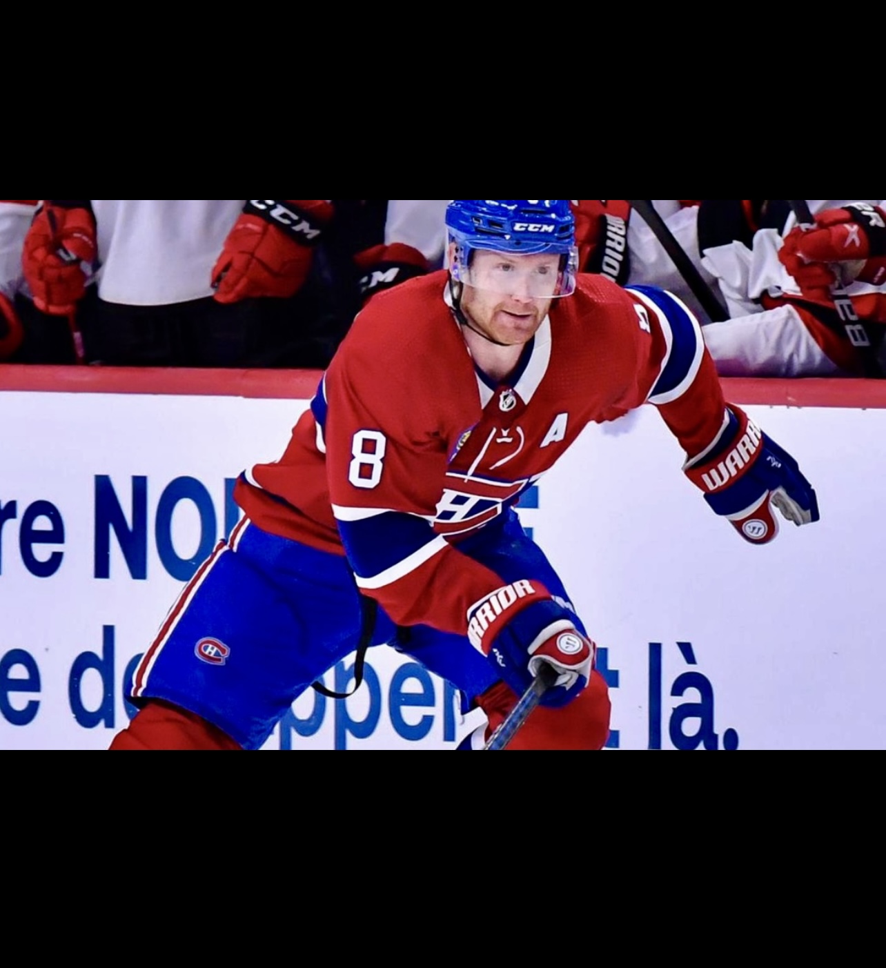 Un joueur de hockey Canadien se réjouit en patinant sur la glace.