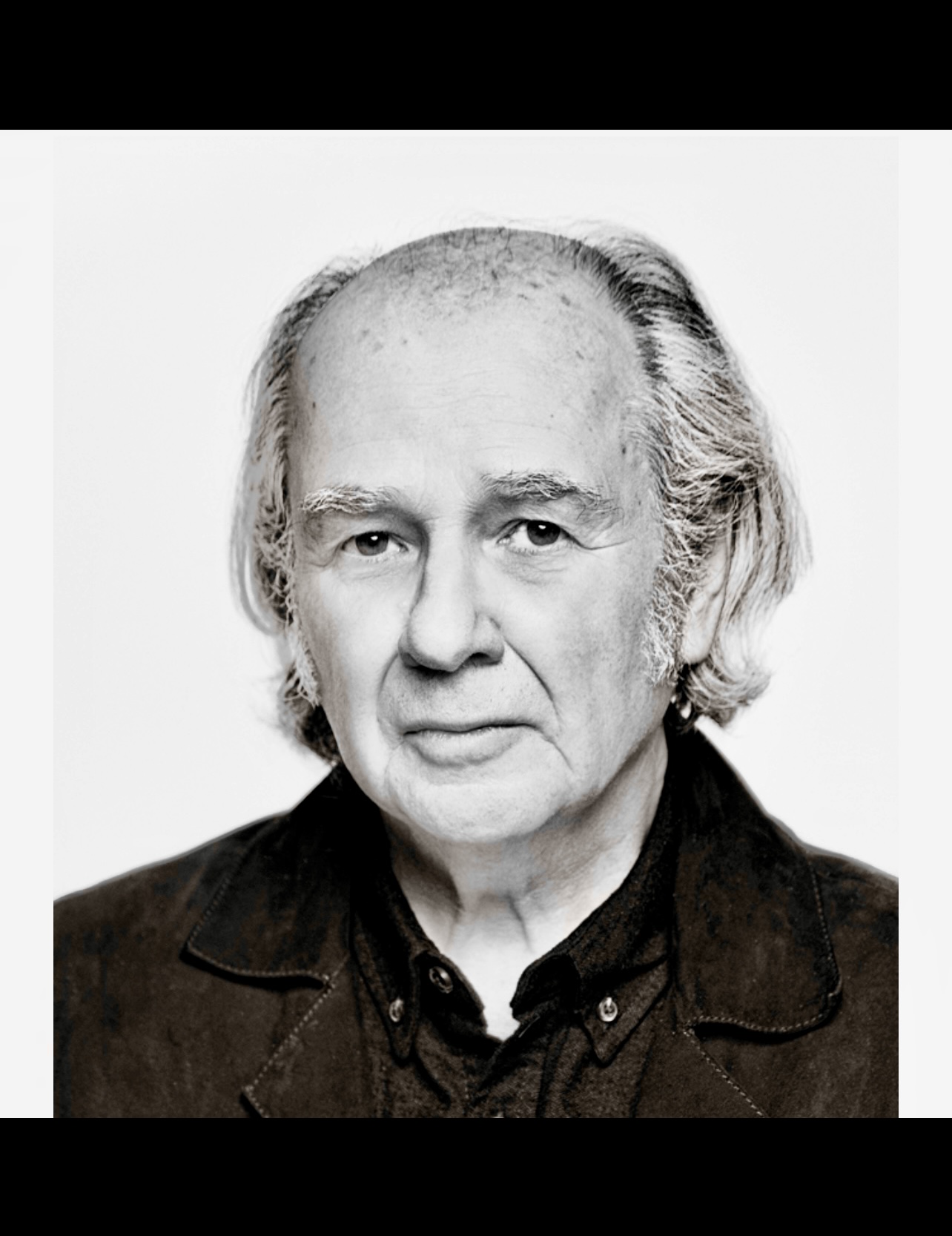 Une photo en noir et blanc de Pierre Ouellet, un homme plus âgé à l'expression mélancolique.