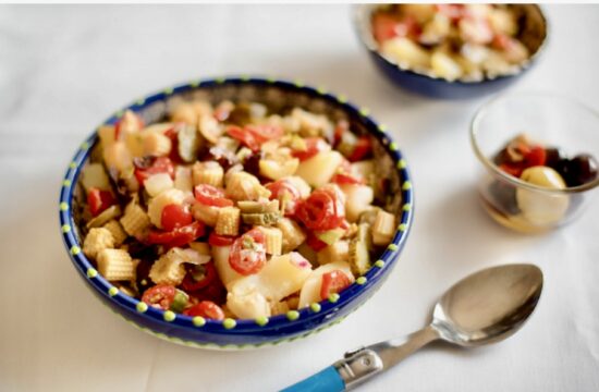 Un bol de salade de pâtes aux tomates et aux olives.
