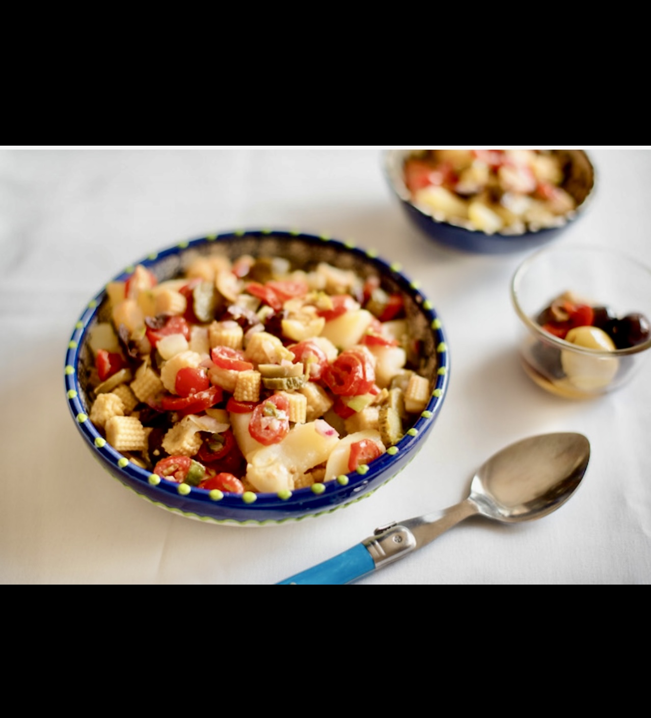 Un bol de salade de pâtes aux tomates et aux olives.