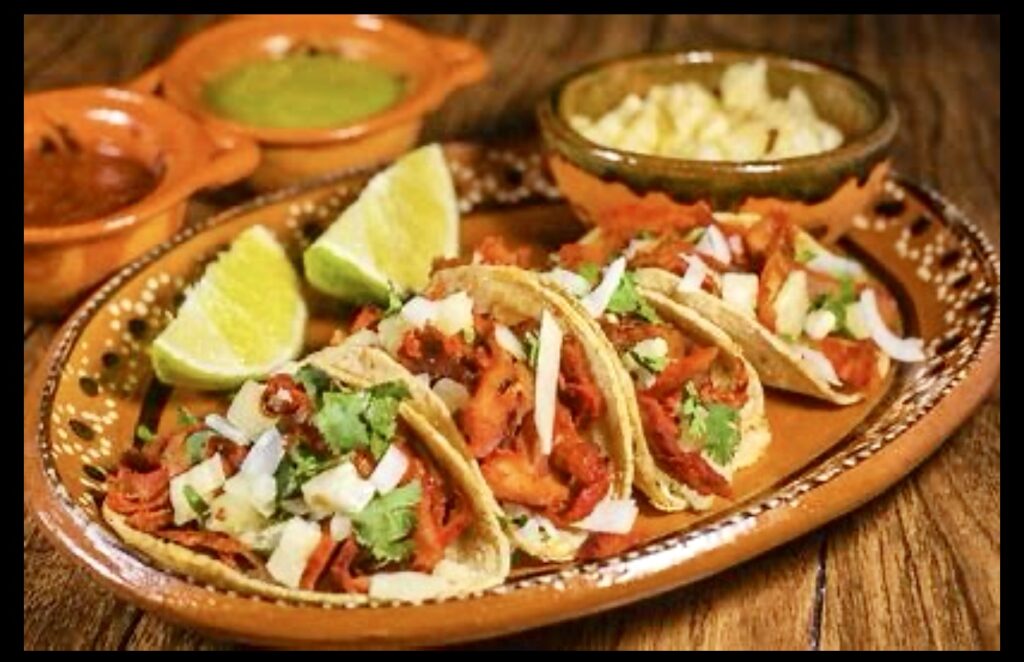 Tacos de la Riviera Maya servis sur une assiette avec des quartiers de citron vert.